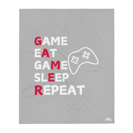 Game, Eat, Sleep Repeat Logo on a white mug with grey throw blanket